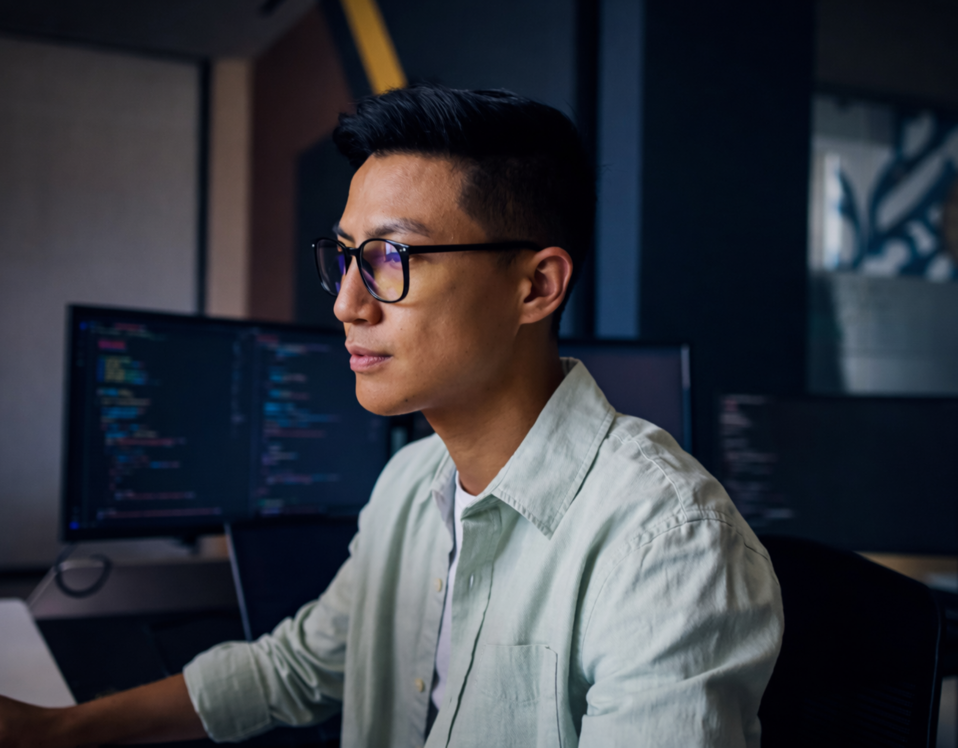 asian male in glasses working at a computer