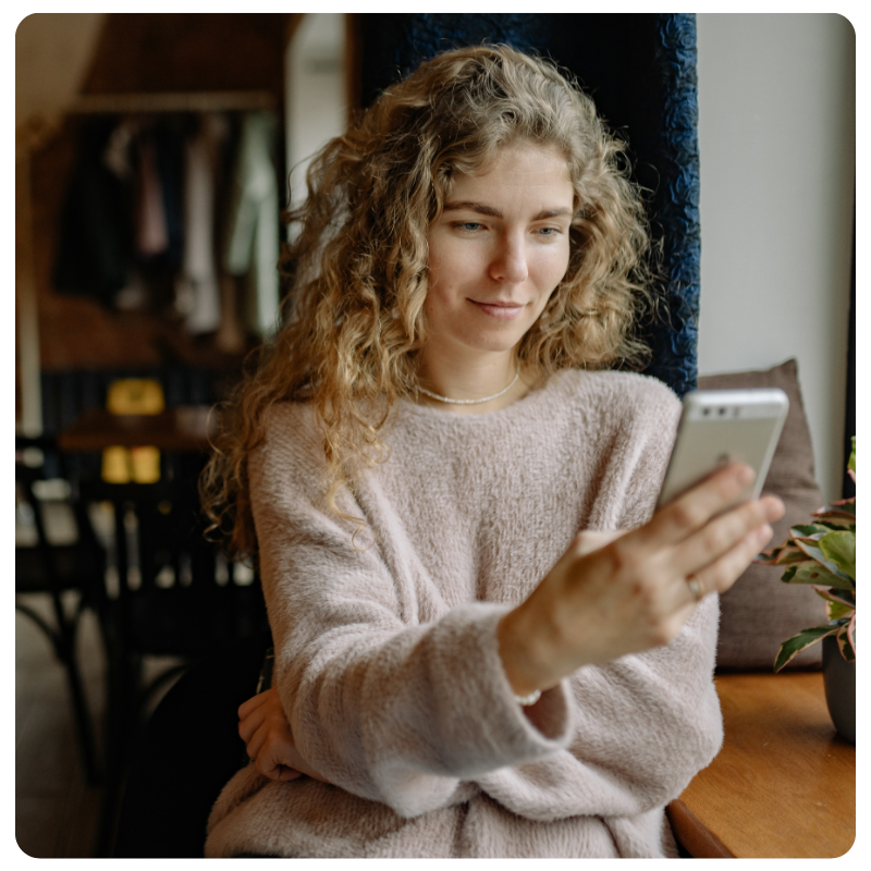 a white female looking at her mobile phone