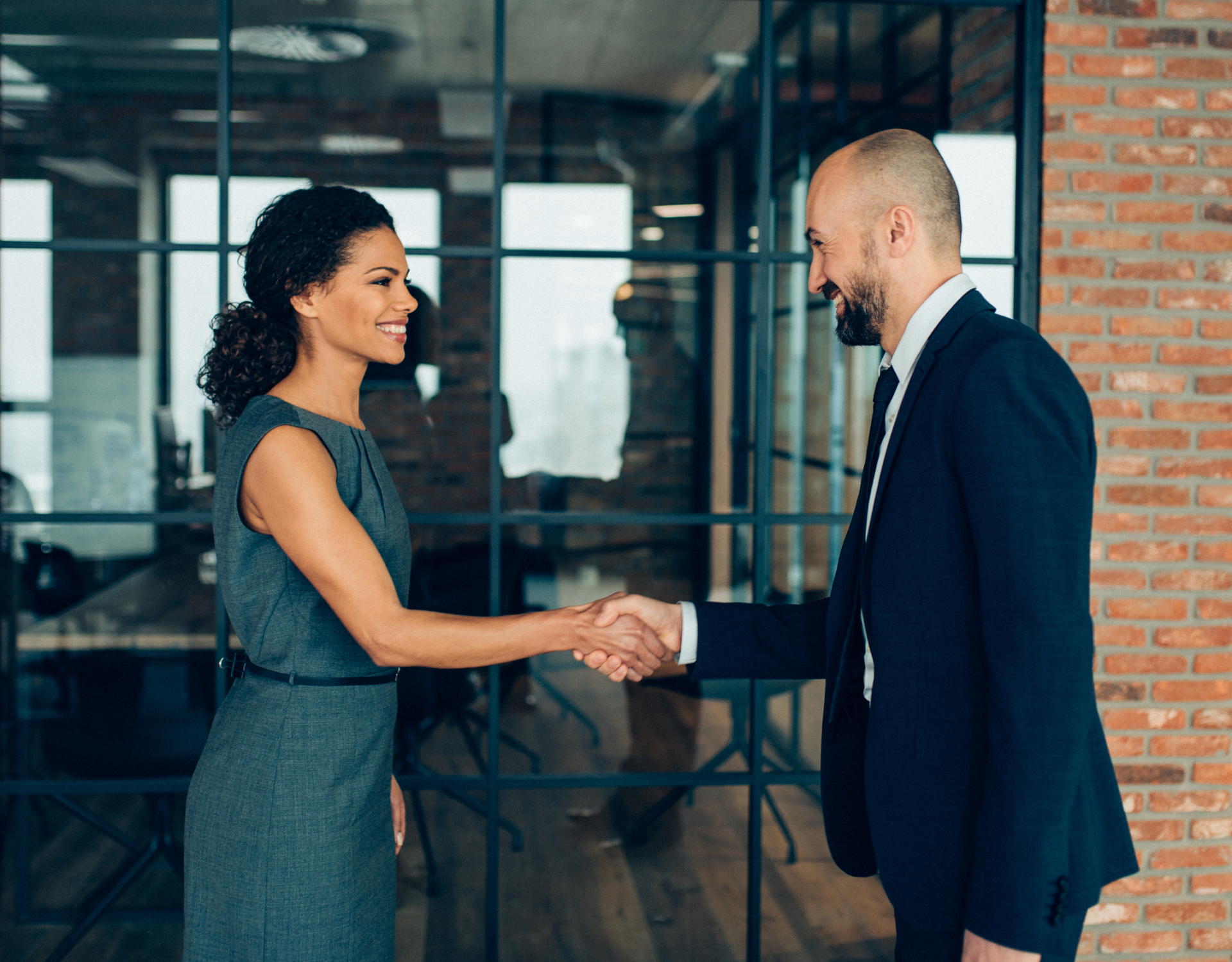 Two professionals shaking hands representing partnership, collaboration, and community connection.