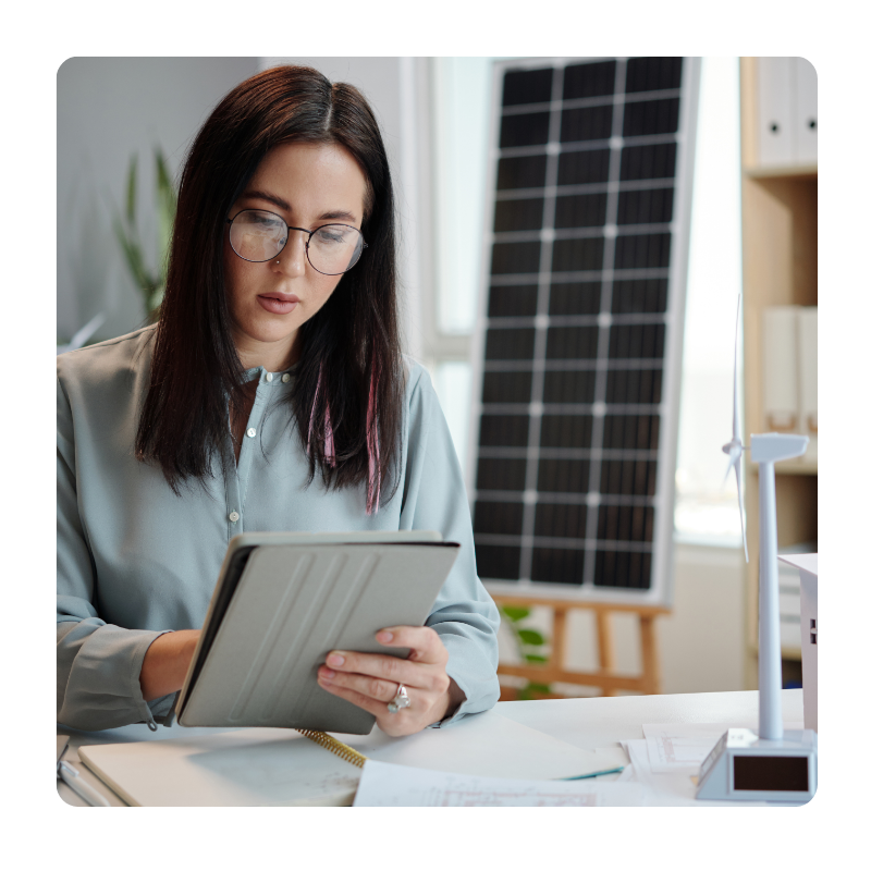 young female in glasses looking at a tablet screen