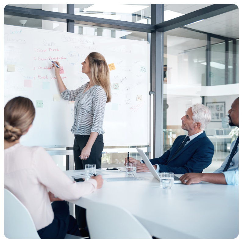 young white female demonstrating notes on a whiteboard